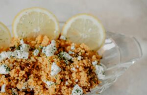 Voyage en cuisine au Maroc : découvrez l’art culinaire de préparer le couscous Famille préparant le couscous marocain avec des épices chaudes et herbes aromatiques