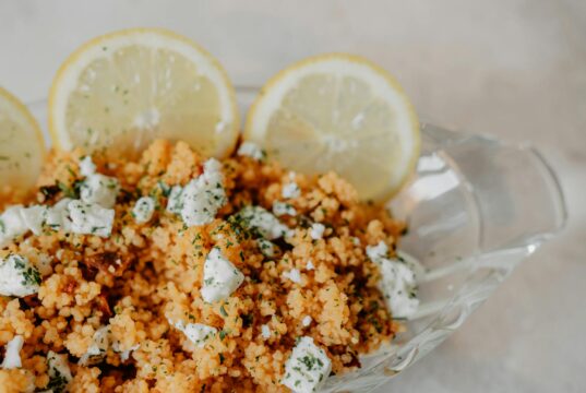 Voyage en cuisine au Maroc : découvrez l’art culinaire de préparer le couscous Famille préparant le couscous marocain avec des épices chaudes et herbes aromatiques