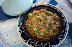 Couscous algérien traditionnel : Recette authentique du couscous aux médaisons de bœuf Famille algérienne autour d'une table de cuisine, préparant un couscous aux médailes de bœuf