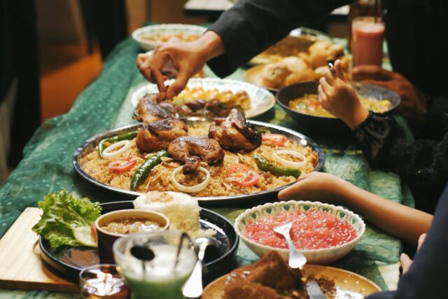 Family enjoying a traditional Maghrebin Ramadan feast with tajine de poisson au citron et aux olives vertes