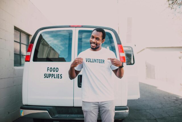 Influenceuse maghrébine donnant une bouteille d'eau à un enfant marocain dans une région rurale