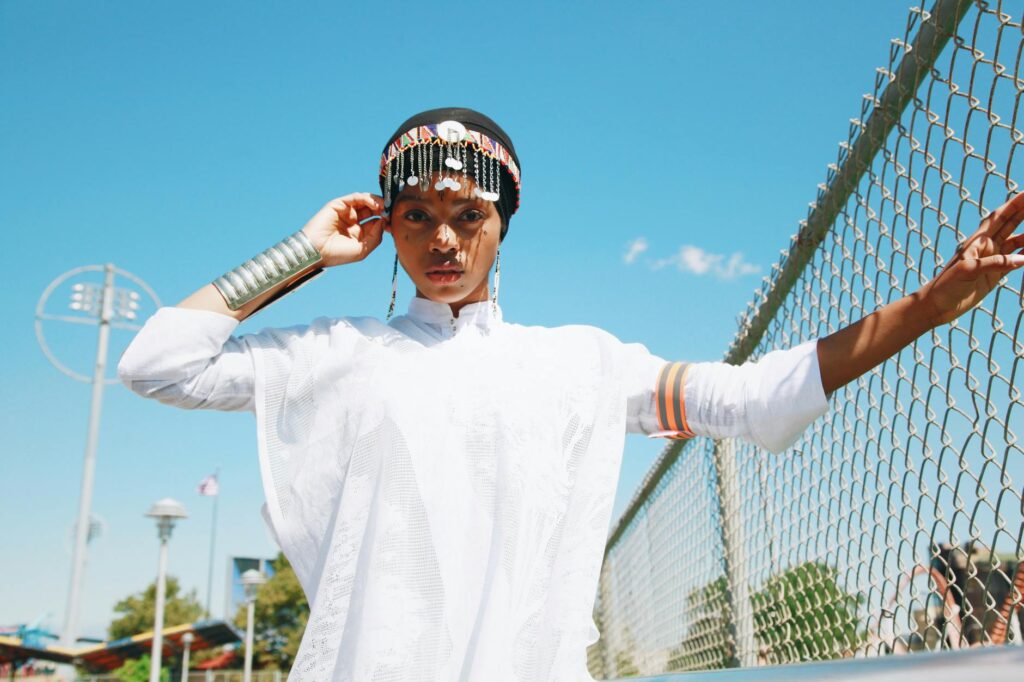 Fatma Ben Abdallah in a contemporary Maghrebian dress, posing in front of a Moroccan backdrop