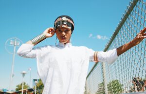 Fatma Ben Abdallah : créations fluides et mode maghrébine contemporaine Fatma Ben Abdallah in a contemporary Maghrebian dress, posing in front of a Moroccan backdrop