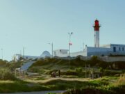 La Tunisie, nouvelle rivale du Maroc en tourisme 2025 : un changement imminent? Tunisian beach resort with Moroccan Atlas Mountains in background, family enjoying sunset