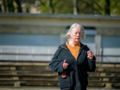 Les cheveux gris : un allié secret pour la santé et la prévention du cancer woman with healthy gray hair smiling at camera, symbolizing good health and cancer prevention