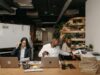 Faire des affaires au Maroc : un guide complet pour les entreprises maghrébines de la diaspora Businesswoman shaking hands with Moroccan man in a bustling office setting