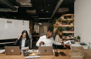 Faire des affaires au Maroc : un guide complet pour les entreprises maghrébines de la diaspora Businesswoman shaking hands with Moroccan man in a bustling office setting