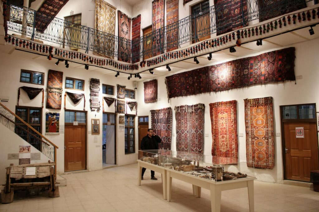 Historian examining a vibrant Moroccan rug under a museum spotlight