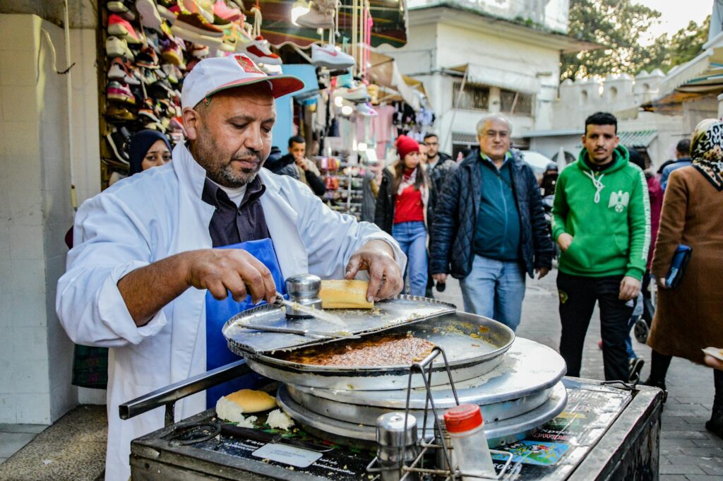 Tunisian street food vendors serving delicious dishes to a happy crowd