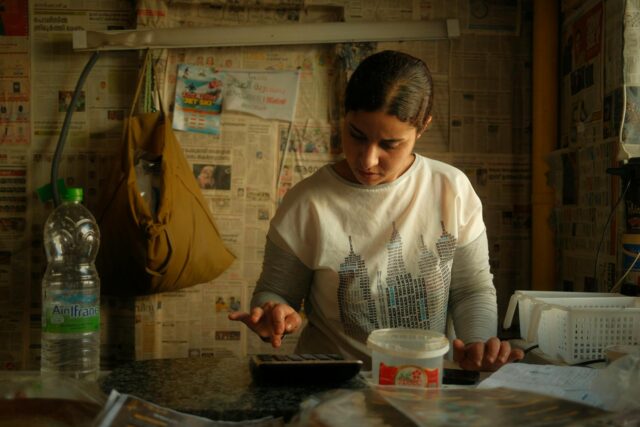 Femme au Maroc sortant de puits avec eau, regardant vers la caméra en contexte de lutte pour sa protection