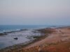 Le Maroc en tant que destination majeure en Afrique : un nouvel attrait touristique Famille qui voyage en Maroc, sur une plage d'or avec des palmes et un paysage montagneux dans le fond