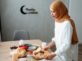 une famille marocaine autour d'une table, en train de préparer du sellou (sfouf) pendant le ramadan