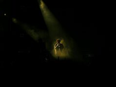 Sid Ali Driss : Un regard sur l’évolution de la musique chaâbi Sid Ali Driss en concert avec une foule enthousiaste derrière lui, en tenue de musique chaâbi.