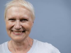 Cheveux gris et cancer : une théorie à découvrir Femme âgée aux cheveux gris regardant son reflet dans un miroir