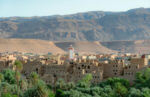 Oasis marocaines : les parfums et la culture d’un environnement oublié Women wearing traditional clothing in a lush oasis amidst the Moroccan desert