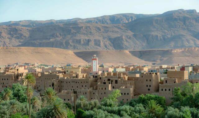 Women wearing traditional clothing in a lush oasis amidst the Moroccan desert