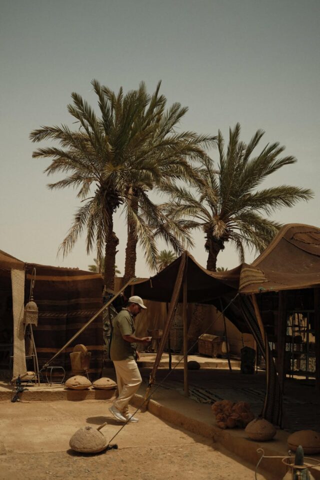 Couple standing among vibrant wildflowers amidst giant palms in the Moroccan desert