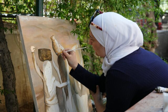 Peintre marocain créant une œuvre inspirée du dialogue sino-arabe