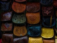 Le sac Talel Paris : fusion de mode et art au Maghreb Une femme portant un sac Talel Paris au Maghreb, avec des mosaïques romaines dans le fond
