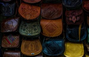 Le sac Talel Paris : fusion de mode et art au Maghreb Une femme portant un sac Talel Paris au Maghreb, avec des mosaïques romaines dans le fond