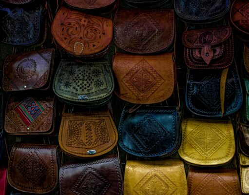 Le sac Talel Paris : fusion de mode et art au Maghreb Une femme portant un sac Talel Paris au Maghreb, avec des mosaïques romaines dans le fond