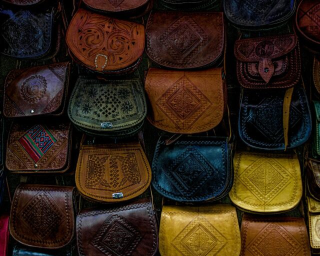 Une femme portant un sac Talel Paris au Maghreb, avec des mosaïques romaines dans le fond