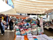 La célébration des cultures à Belmkaddem : entre artisanat et tradition Woman shopping for traditional Moroccan goods at the Belmkaddem Festival of Heritage