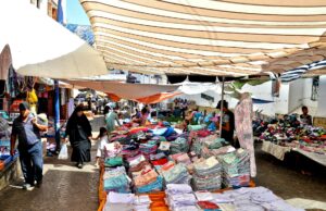 La célébration des cultures à Belmkaddem : entre artisanat et tradition Woman shopping for traditional Moroccan goods at the Belmkaddem Festival of Heritage