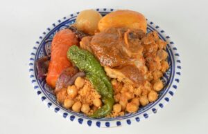 La cuisine berbère dans les montagnes de l’Atlas : découvrez les recettes authentiques Famille à table avec des plats traditionnels de cuisine berbère dans les montagnes enneigées de l'Atlas