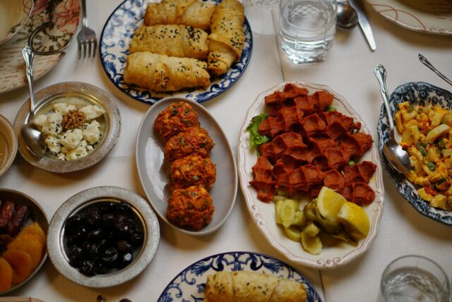 Family gathering around a table filled with over 100 delicious Maghrebin dishes during Ramadan 2026