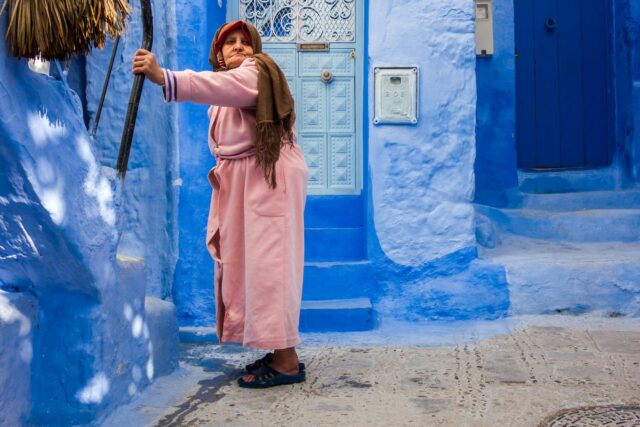 Woman wearing traditional Chefchaouen fashion in a colorful street