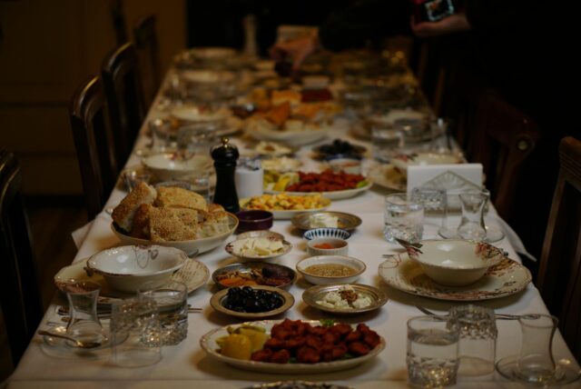 Familie arabo-berbère à la table pour le ramadan, serviettes blanches sur la table, bouffe de couscous accompagné d'un plat e