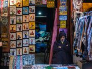 Comment gérer efficacement les factures élevées de l’opéra-mobile en vacances au Maroc Traveler using mobile phone at Moroccan marketplace