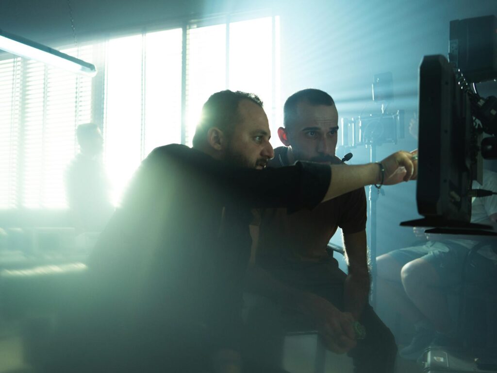Moroccan woman, Rabat cityscape with palm trees, watching a Franco-Moroccan film, 'Derriere les Palmiers', on laptop