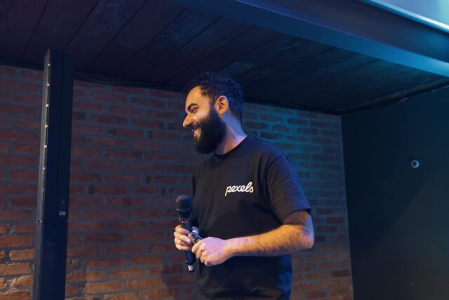 Mehdi Bensaid discutant devant une foule, avec le logo de la Coupe du monde 2030 au Maroc dans le fond