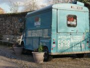 La nouvelle tendance du mariage traditionnel en France : photobooths et food-trucks Famille en costume de mariage avec photobooth et food-truck à l'arrière-plan
