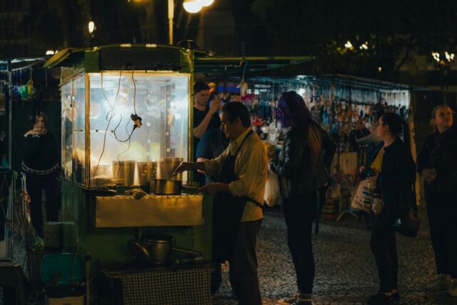 Algerian street food vendor serving flavorful dishes to a crowd