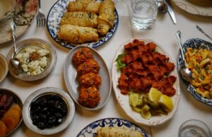 10 recettes saines pour la première journée de Ramadan 2026 : nourrir votre corps et votre âme Famille arabe mangeant ensemble en se tenant à la table pendant Ramadan avec des recettes saines