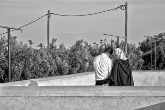 Moroccan family discussing phone bill at riad during holiday in Marrakech
