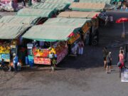 Le tourisme marocain bat des records en 2025 : chiffres étonnants Foreign tourists visiting Moroccan marketplace in 2025