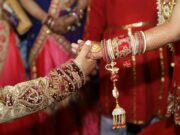 Assistance à un mariage indien : expérience humaine inoubliable Indian bride and groom in traditional attire surrounded by family and friends during wedding ceremony