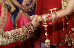 Assistance à un mariage indien : expérience humaine inoubliable Indian bride and groom in traditional attire surrounded by family and friends during wedding ceremony