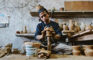 Un artisanat marocain de Cherbourg-en-Cotentin : Une nouvelle voie vers l’artisanat traditionnel Artisan marocain travaillant à son atelier de Cherbourg-en-Cotentin avec ses créations en vue