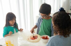 Recette traditionnelle des msemen : pas à pas vers la perfection Famille algérienne en train de préparer des msemen, délicieux plats crépés à base de farine et de beurre