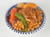 Cocas algériennes aux poivrons : recette traditionnelle et croustillante Famille algérienne mangeant des cocas aux poivrons verts et rouges sur une table à l'extérieur