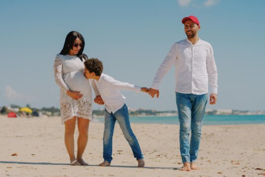 L’été algérien : records et complications à la Tunisie Famille algérienne sur plage tunisienne, face à la montagne et au ciel chaud
