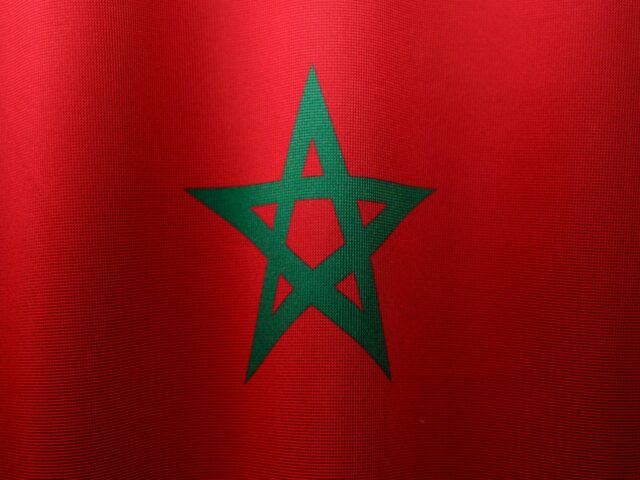 French and Moroccan officials shaking hands in front of a cultural monument
