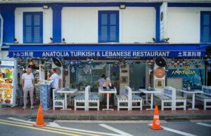 Algérien restaurant à Singapour: expérience gastronomique inoubliable Algérien restaurant à Singapour : famille et amis mangent une délicieuse tagine sur un bel balcon en plein air