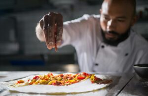 Mohamed Cheikh, gagnant de Top Chef 2021 : Promouvoir la cuisine algérienne Mohamed Cheikh avec un plat d'algérie, tenant le trophée de Top Chef 2021