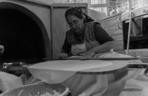 Tout ce que vous devez savoir sur les msemen : techniques et recettes woman preparing Tunisian Msemen with a rolling pin and ingredients on a countertop